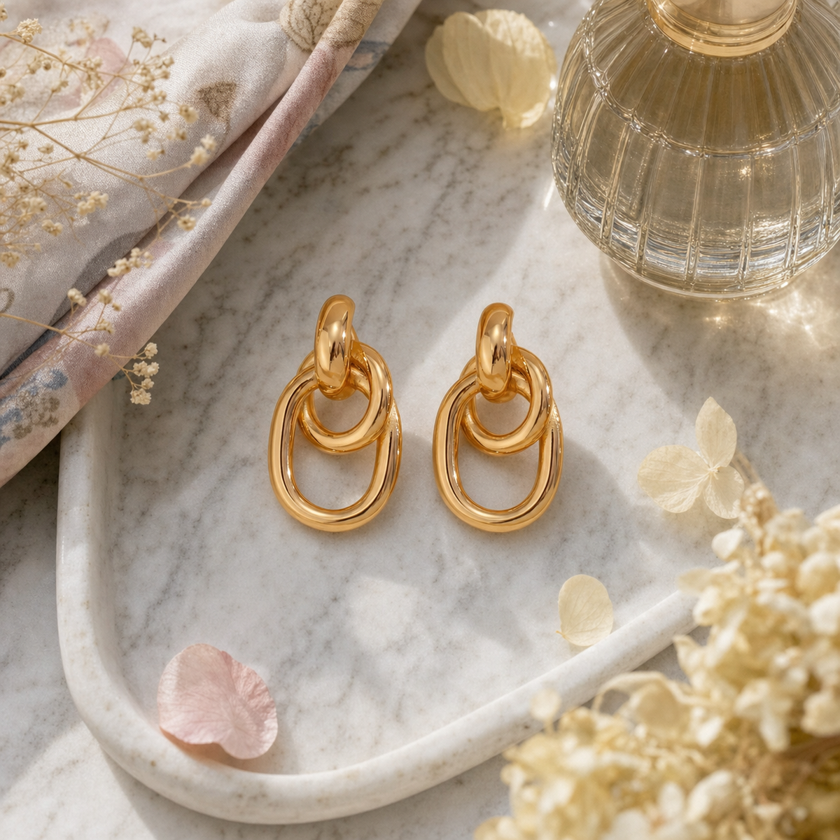 18k gold plated stainless steel double link chain drop earrings in gold and two-tone gold silver finish, hypoallergenic tarnish resistant statement earrings by The Intertwined Collective, Dallas Texas, displayed on a white marble tray with florals