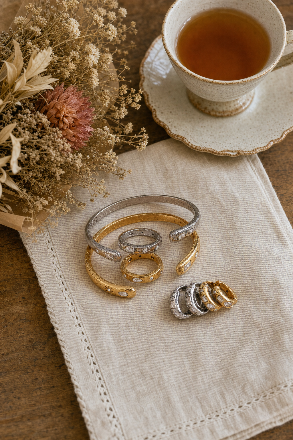 Gold and silver celestial gem huggie earrings together, hypoallergenic tarnish resistant mixed metal hoops, Dallas Texas, displayed on a linen napkin with dried florals and tea