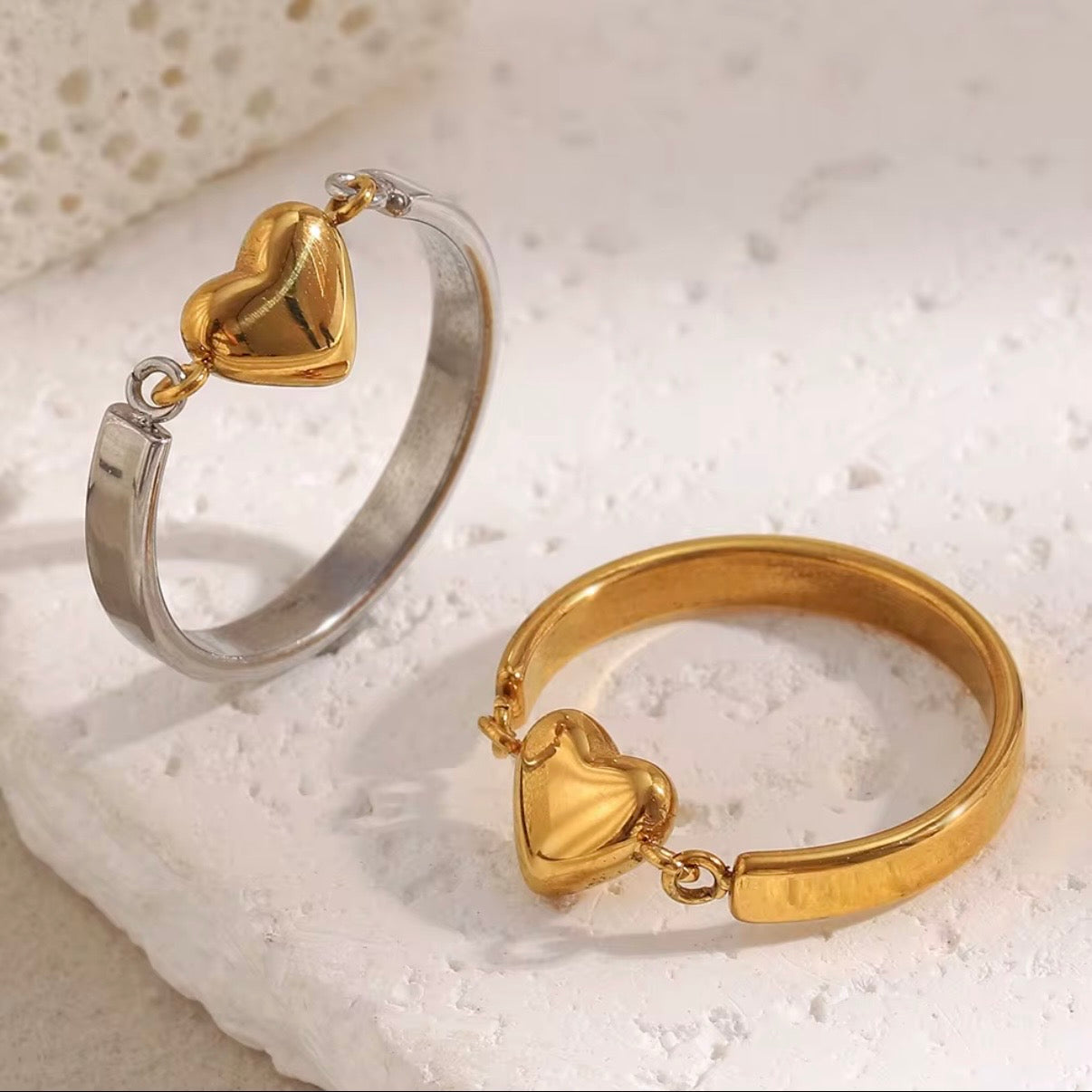 Gold and two‑tone open band rings with linked 3D puffy heart charm centerpiece on textured white surface – hypoallergenic water and tarnish resistant heart rings