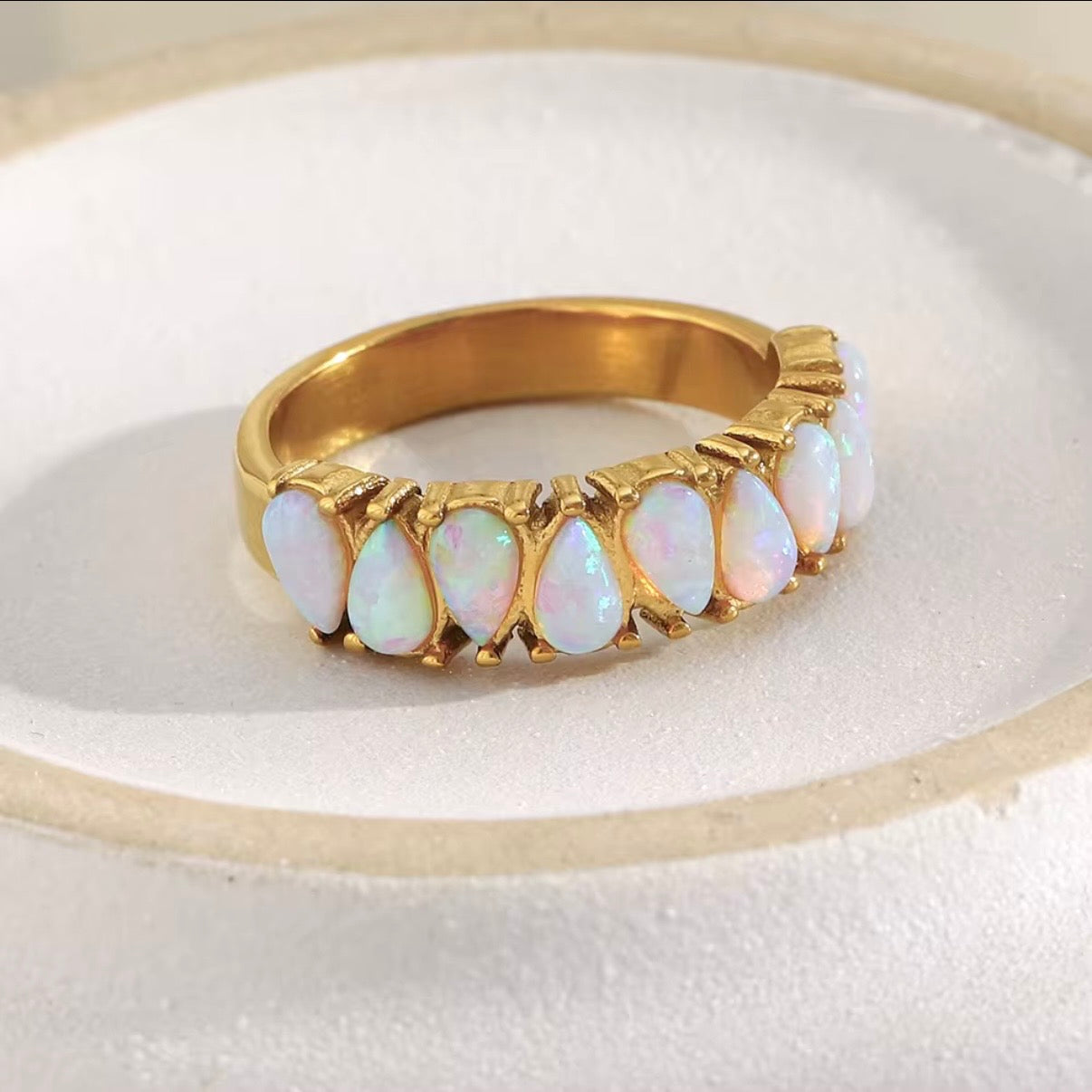 Gold ring with opal stones on a white background