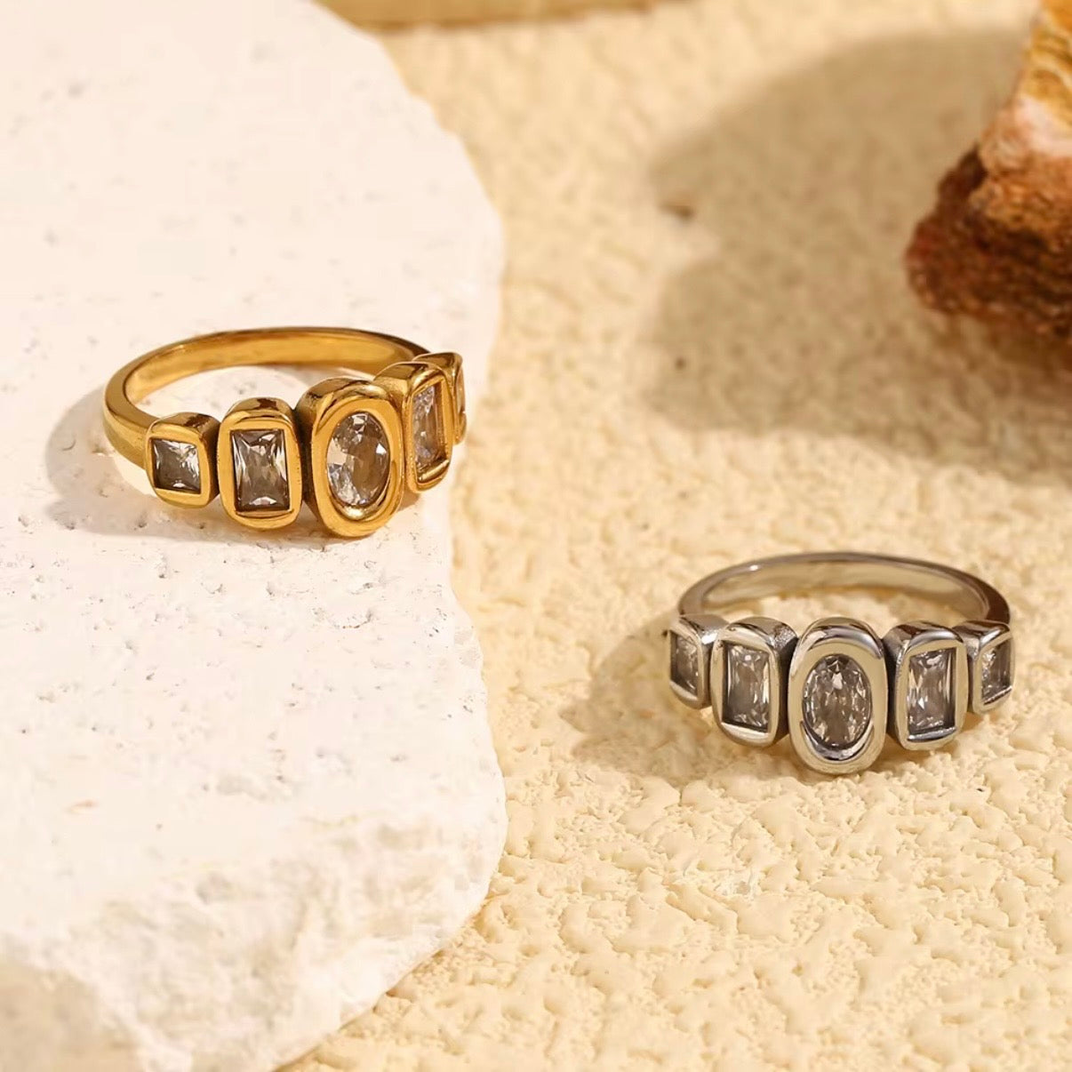 18k gold plated and silver tone stainless steel five-stone mixed-cut CZ bezel band ring with oval, emerald-cut, and princess-cut clear cubic zirconia stones, hypoallergenic tarnish resistant fine jewelry-inspired ring by The Intertwined Collective