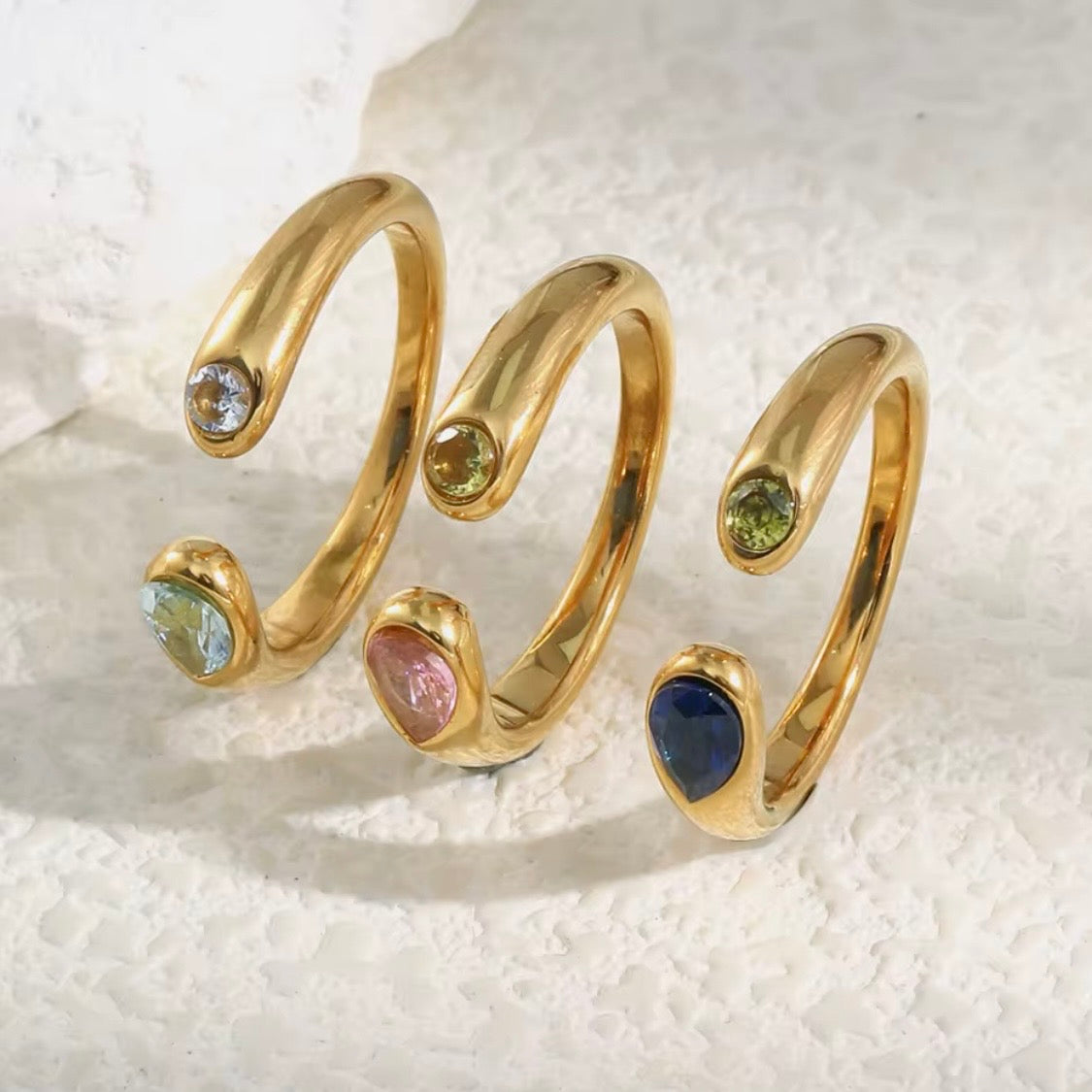 18k gold plated stainless steel dual-stone open coil ring with bezel-set round and pear-cut CZ stones, available in green, pink, and blue, hypoallergenic tarnish resistant stackable ring by The Intertwined Collective
