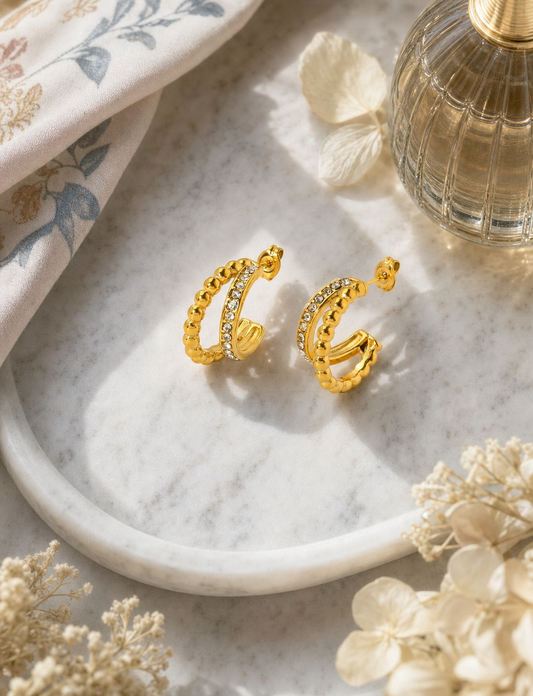 18k gold plated stainless steel double band beaded and CZ hoop earrings in clear and emerald green, hypoallergenic tarnish resistant stacked hoop earrings by The Intertwined Collective, Dallas Texas displayed on a white marble tray with florals