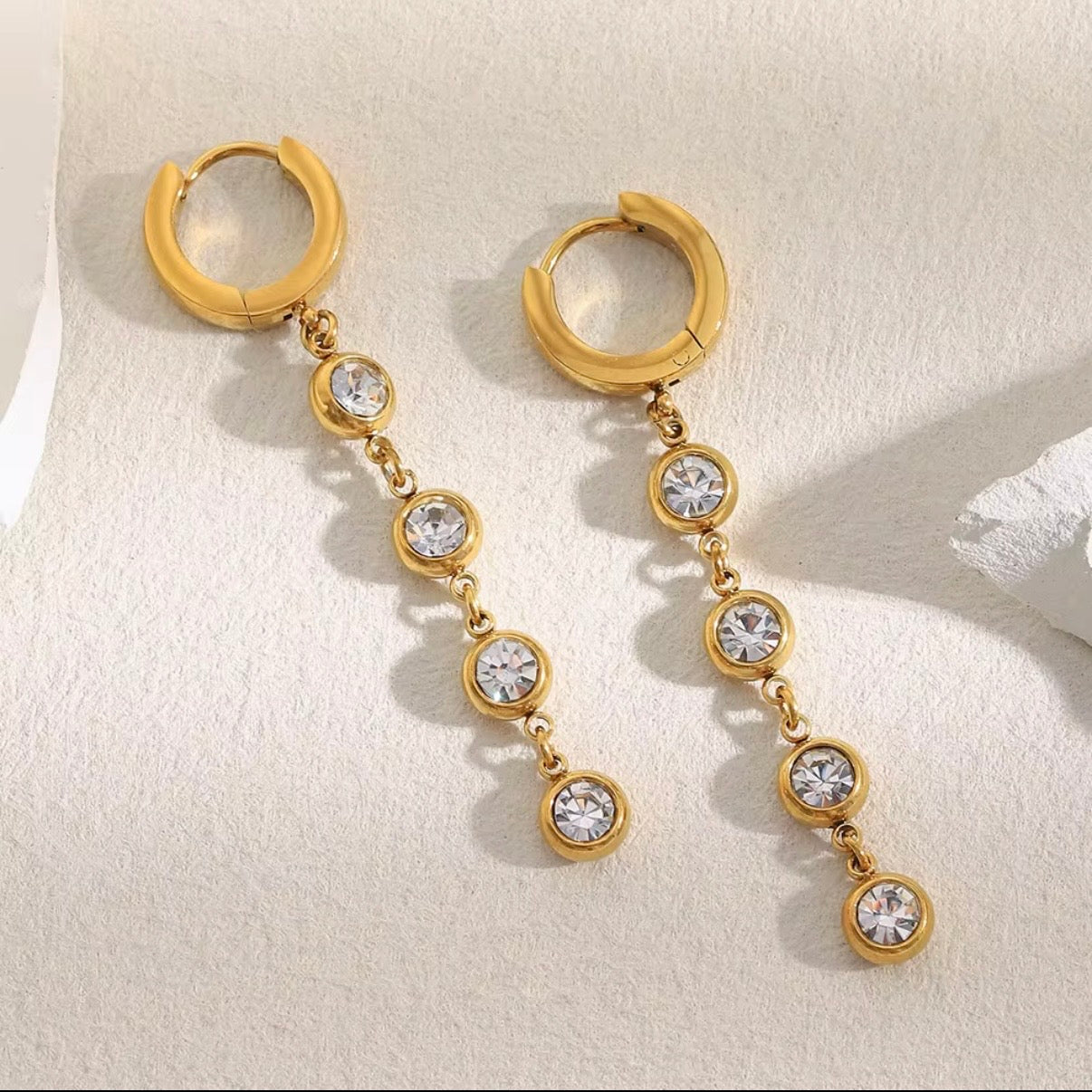 18k gold plated stainless steel huggie hoop earrings with cascading bezel-set CZ crystal chain drop, hypoallergenic tarnish resistant sparkle drop earrings by The Intertwined Collective, Dallas Texas