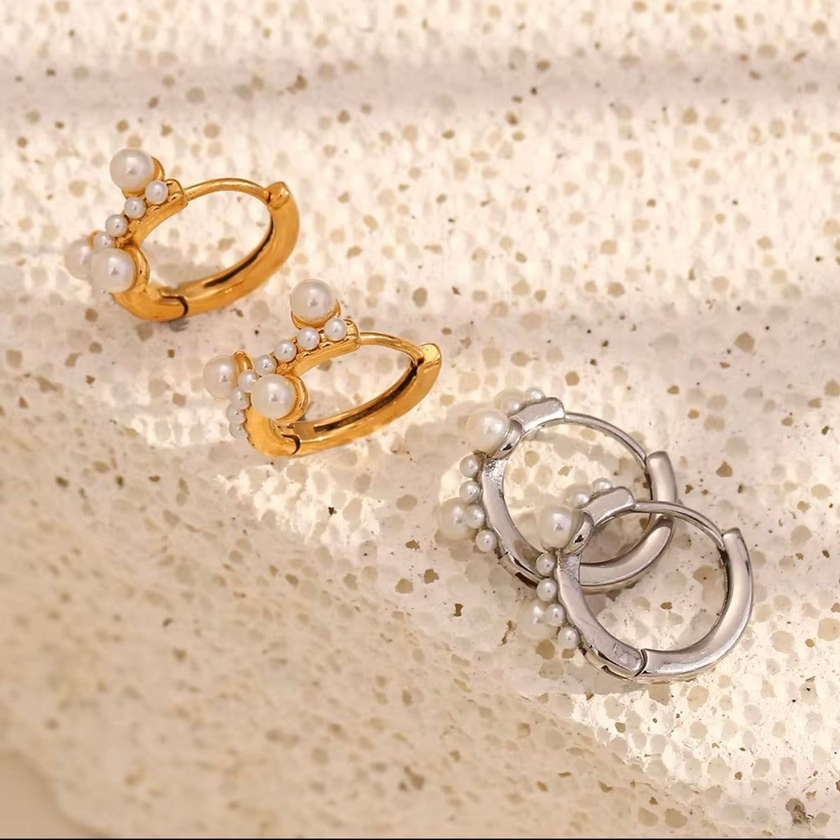 Gold and silver pearl cluster huggie hoop earrings with graduated faux pearl accent displayed on neutral stone surface — hypoallergenic water-resistant tarnish-resistant dainty stackable huggies by The Intertwined Collective, Dallas Texas