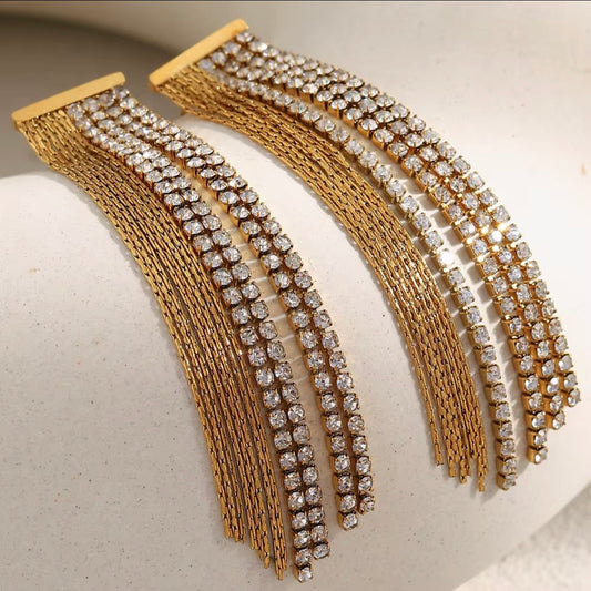 Crystal & Gold Chain Fringe Wave Earrings by The Intertwined Collective – long 18k gold pavé CZ and gold chain fringe dangles in a sweeping wave design. Hypoallergenic, water and tarnish resistant. Shop glamorous statement earrings now.