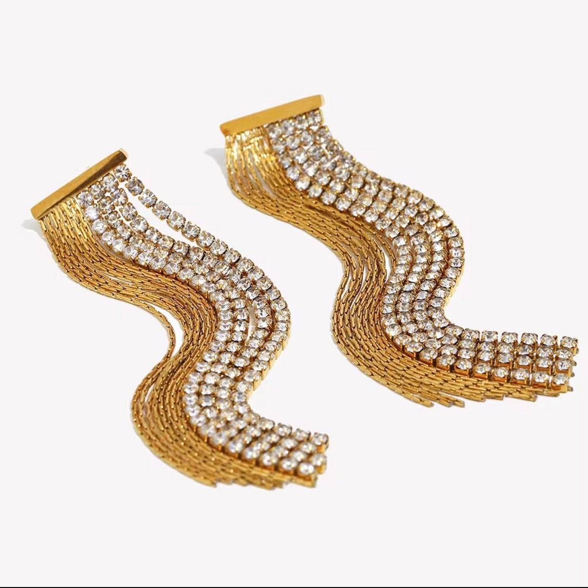 Crystal & Gold Chain Fringe Wave Earrings by The Intertwined Collective – long 18k gold pavé CZ and gold chain fringe dangles in a sweeping wave design. Hypoallergenic, water and tarnish resistant. Shop glamorous statement earrings now.