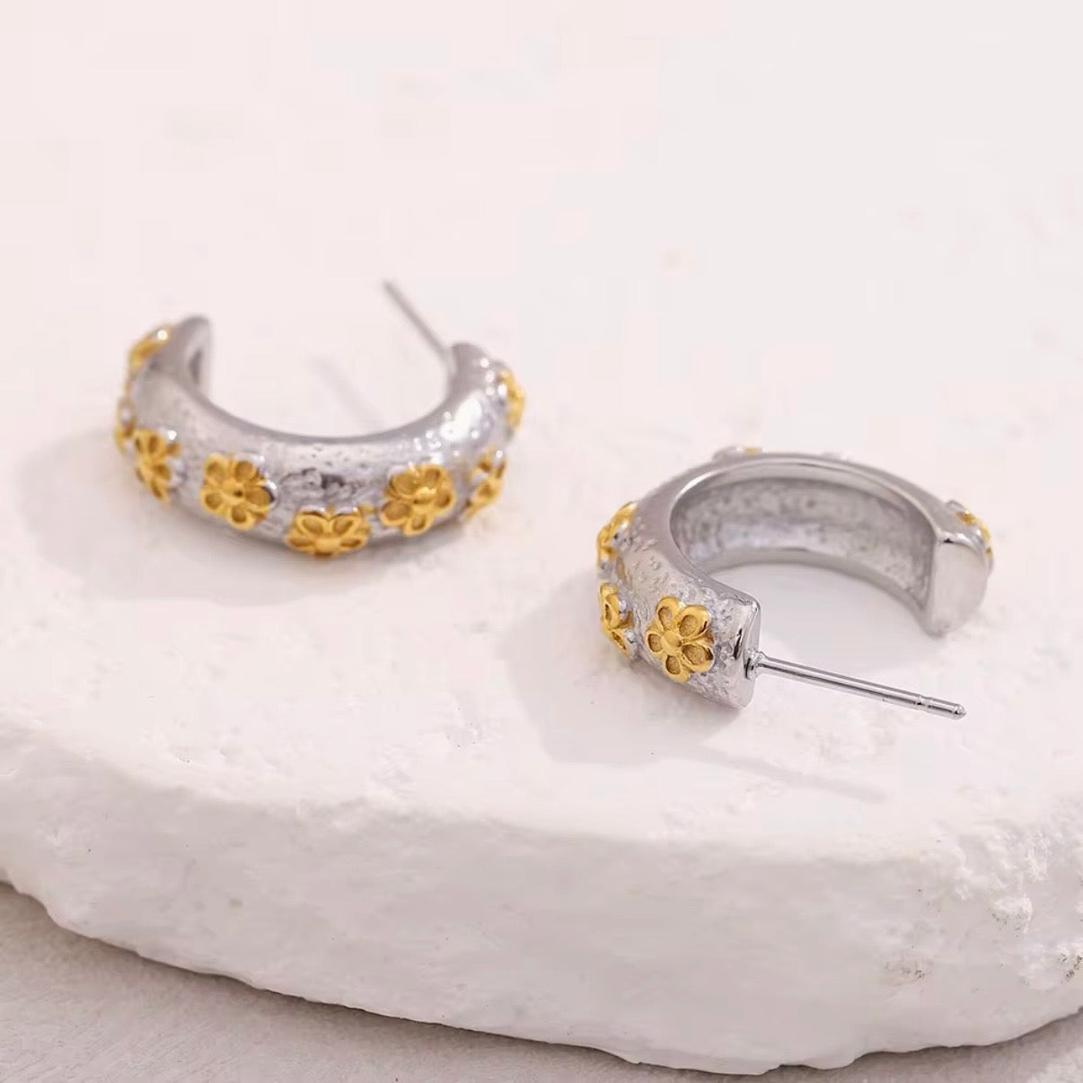 Gold textured huggie hoop earrings with raised floral pattern and tiny crystal accents on black earring card – hypoallergenic, water- and tarnish‑resistant mini hoops