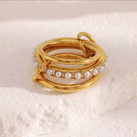 Gold linked triple multi-band rings with center row of faux pearls displayed on wooden ring cones – hypoallergenic water and tarnish resistant pearl statement rings