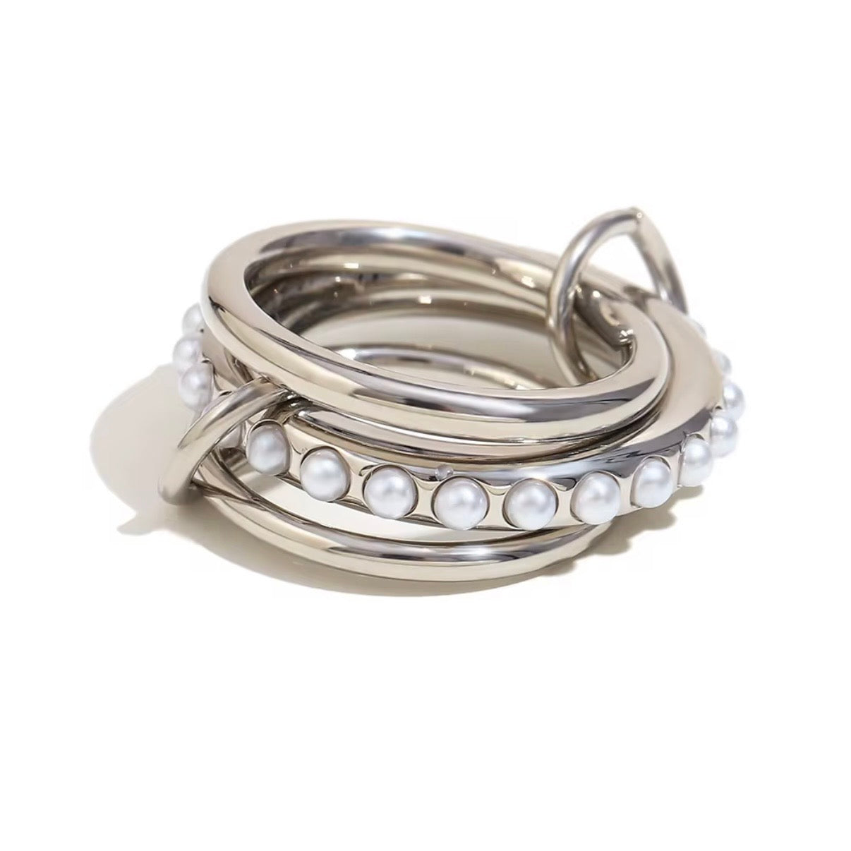 Silver linked triple multi-band rings with center row of faux pearls displayed on wooden ring cones – hypoallergenic water and tarnish resistant pearl statement rings