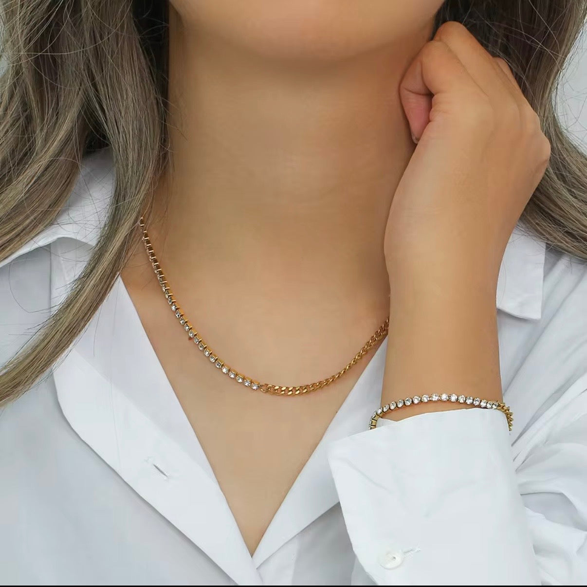 Gold split necklace with half CZ tennis strand and half gold curb chain displayed on soft beige fabric – hypoallergenic water and tarnish resistant necklace