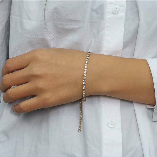 Gold bracelet with half CZ tennis strand and half gold curb chain displayed on soft beige fabric – hypoallergenic water and tarnish resistant bracelet