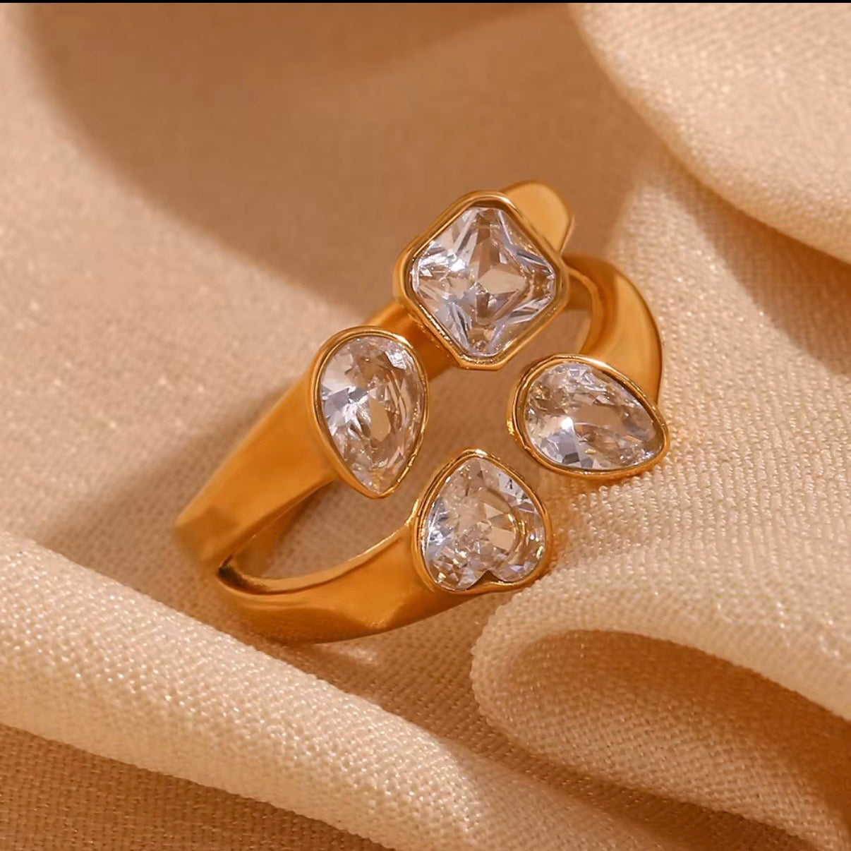 18k gold plated stainless steel mixed-cut CZ cluster statement ring with princess, pear, and heart-cut bezel-set clear cubic zirconia stones in cross formation, hypoallergenic tarnish resistant cocktail ring by The Intertwined Collective