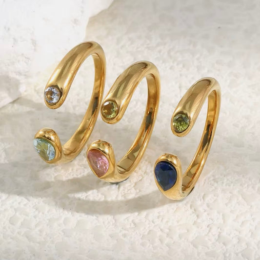 18k gold plated stainless steel dual-stone open coil ring with bezel-set round and pear-cut CZ stones, available in green, pink, and blue, hypoallergenic tarnish resistant stackable ring by The Intertwined Collective