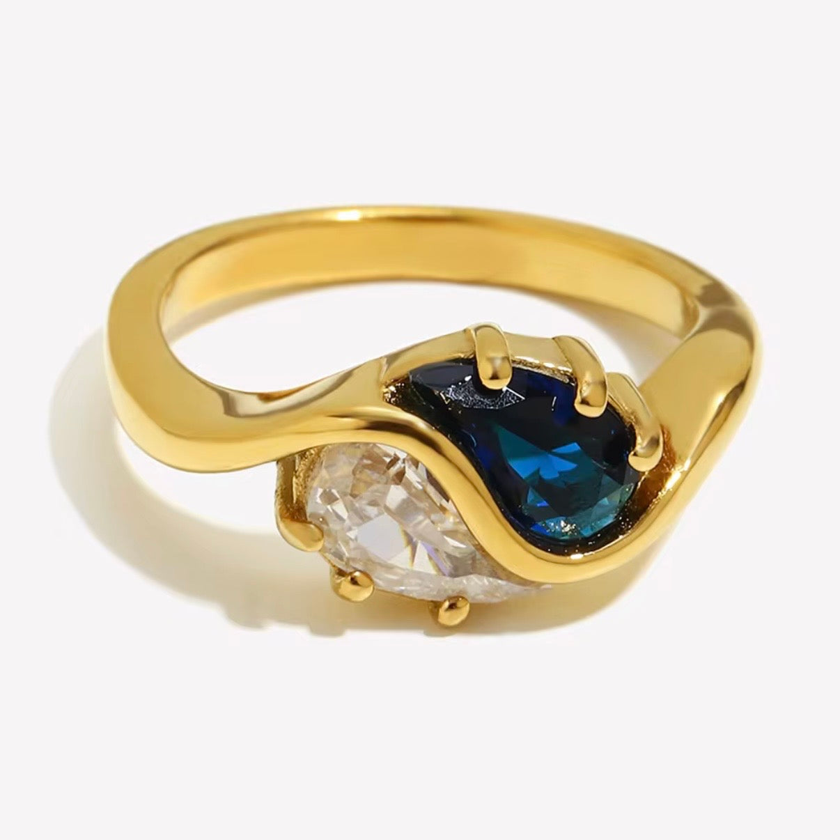 18k gold plated stainless steel toi et moi bypass ring with dual prong-set pear-cut sapphire blue and clear CZ stones in a fluid wave bypass setting, hypoallergenic tarnish resistant bridal-inspired ring by The Intertwined Collective