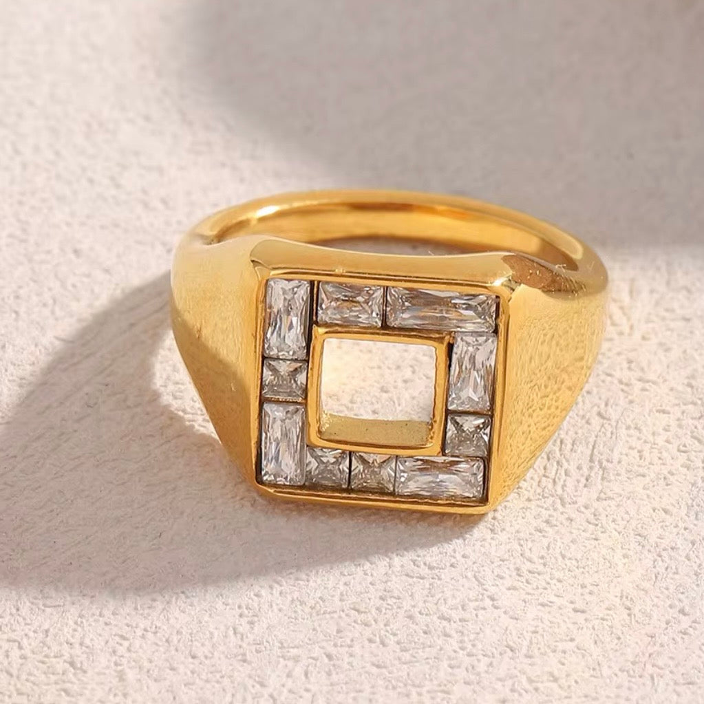 18k gold plated stainless steel wide signet ring with diamond-shaped face, baguette CZ channel-set frame and open square center cutout, hypoallergenic tarnish resistant architectural statement ring by The Intertwined Collective
