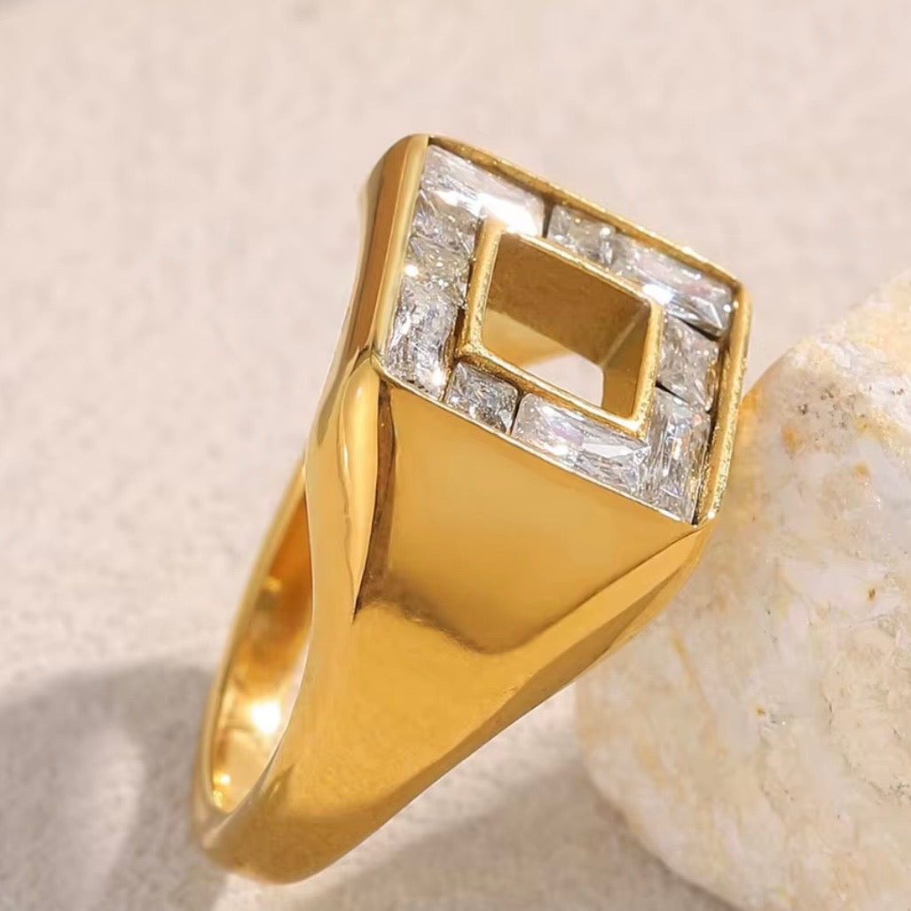 18k gold plated stainless steel wide signet ring with diamond-shaped face, baguette CZ channel-set frame and open square center cutout, hypoallergenic tarnish resistant architectural statement ring by The Intertwined Collective
